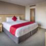 King bed with nightstand in Junior Suite with carpeted floors at Copthorne Hotel Auckland City