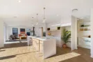 Open-plan white kitchen with island and pantry shelving - Inspire Kitchens