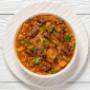 Lamb Tagine- Tender diced lamb, slow cooked in a piquant sauce with almonds and prunes. A balance of savoury and sweet notes and complex flavours – served on a bed of couscous