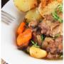 Coq au Vin with Vegetables- A traditional French dish of braised chicken with red wine, bacon, onion, carrots, mushrooms, potato and broccoli.